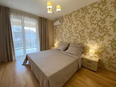 a bedroom with a large bed and a window at Sozopol Apartcomplex Onegin 2,free parking in Sozopol