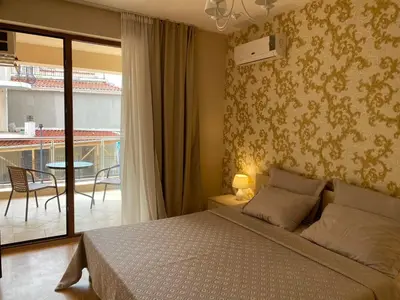 a bedroom with a bed and a balcony at Sozopol Apartcomplex Onegin 2,free parking in Sozopol