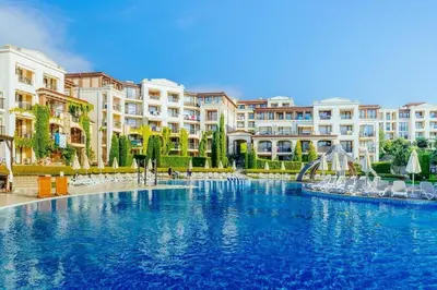 a large swimming pool with chairs and buildings at Smokini Beach Apartment in Sozopol