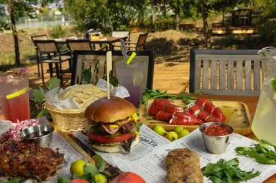 a table with a sandwich and other food on it at Smokini Beach Apartment in Sozopol