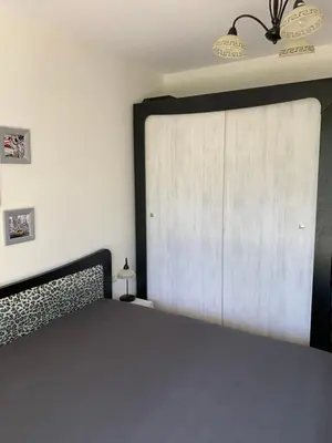 a bedroom with a bed and a sliding door at Апартамент Silver Star in Sozopol