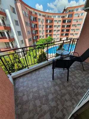 a balcony of a building with a table and a chair at Apartmán TTT in Burgas City