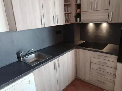 a kitchen with wooden cabinets and a sink at Apartmán TTT in Burgas City