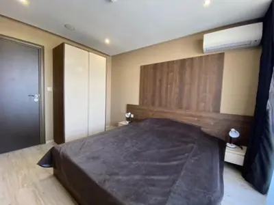 a bedroom with a large bed with a wooden headboard at PARADISO 'B' 605 Private Apartment Nessebar in Nesebar