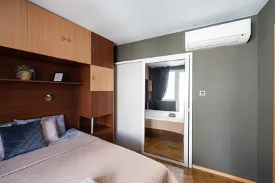 a bedroom with a bed with a mirror and a window at Promenade Rooftop Flat in Varna City