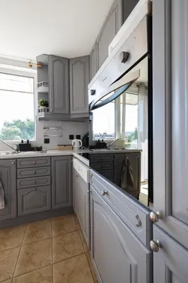 a kitchen with gray cabinets and white counters at Promenade Rooftop Flat in Varna City