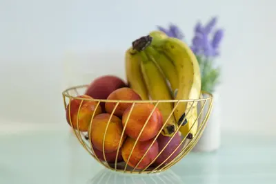 a bowl of fruit with bananas apples and peaches at Promenade Rooftop Flat in Varna City