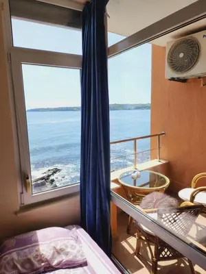 a bedroom with a view of the ocean from a window at Sozopol Bulgaria VIP zona in Sozopol