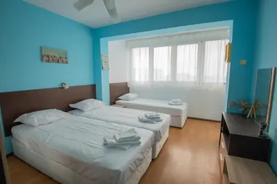 two beds in a room with blue walls at One-bedroom Flat Close to the Sea Garden by Flat Mаnаger in Burgas City