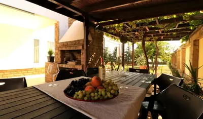a plate of fruit on a table on a patio at Ravda Residence in Ravda