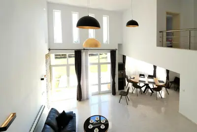 a living room with a table and a dining room at Ravda Residence in Ravda