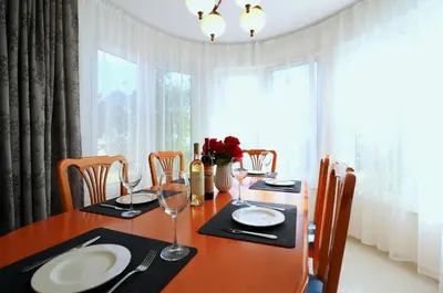 a dining room table with plates and glasses on it at Ravda Residence in Ravda