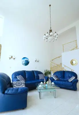 a living room with blue couches and a glass table at Ravda Residence in Ravda
