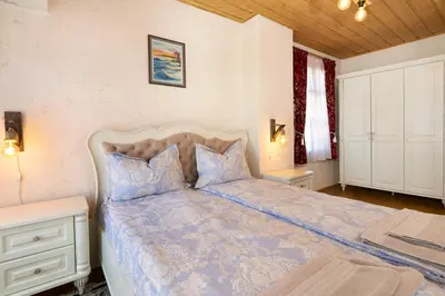 a bedroom with a bed with a blue comforter at ВИЛА ТЪРТЕФФ in Nesebar