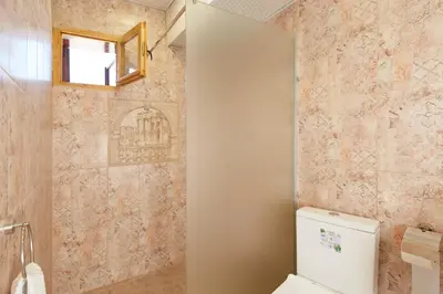 a bathroom with a toilet and a window on the wall at ВИЛА ТЪРТЕФФ in Nesebar