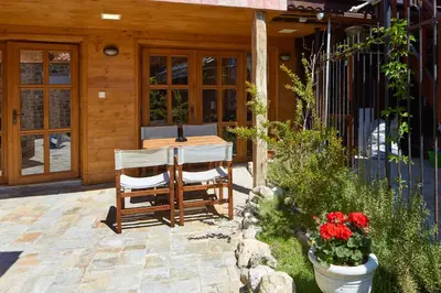 a patio with a table and chairs and flowers at ВИЛА ТЪРТЕФФ in Nesebar