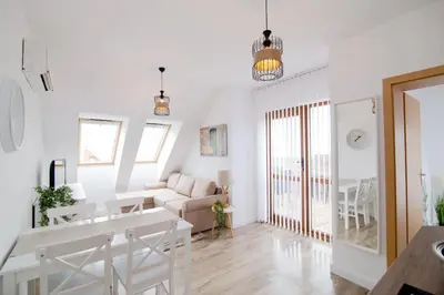 a white living room with a couch and a table at BohoTide by the Sea in Bliznatsi