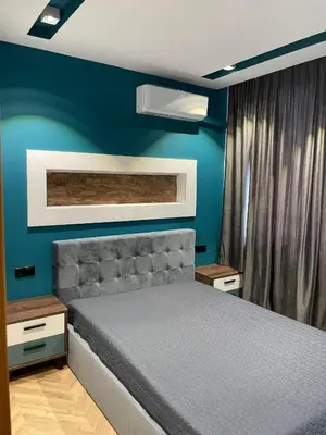 a bedroom with a bed and a blue wall at Sea Scenery Apartment in Burgas City