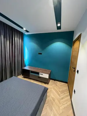 a bedroom with a bed and a blue wall at Sea Scenery Apartment in Burgas City
