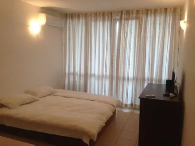 a bedroom with a bed and a desk and a window at Vilmar Studio in Pomorie