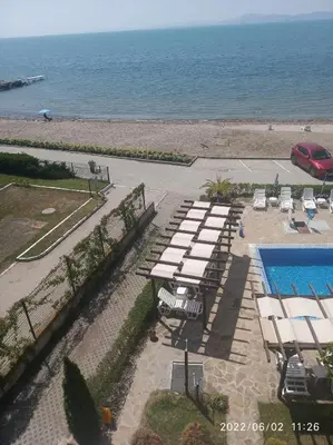 a group of tables and chairs next to the ocean at Vilmar Studio in Pomorie