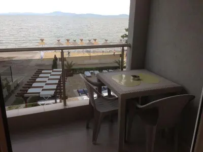 a balcony with a table and chairs and a view of the beach at Vilmar Studio in Pomorie