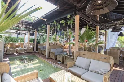 a patio with a couch and chairs and a pool at Oasis Resort & Spa Cozy Studio in Lozenets