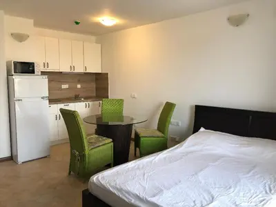 a bedroom with a bed and a table and chairs at Oasis Resort & Spa Cozy Studio in Lozenets
