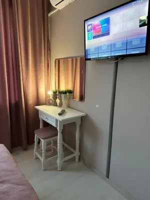a room with a table and a tv on a wall at Guest house “Poli” in Nesebar