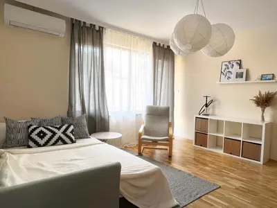 a bedroom with a bed and a chair and a window at Lovely Apartment with Balcony in Pomorie Old Town by Flat Mаnаger in Pomorie
