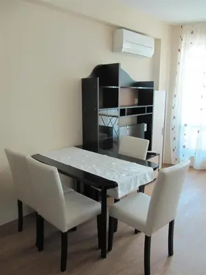 a dining room with a table and chairs and a shelf at Rayski zalez in Pomorie