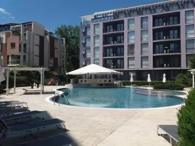 a large hotel with a swimming pool in front of a building at Апартамент в Рейнбоу 3 in Sunny Beach