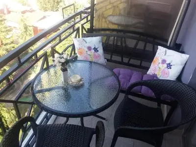 a glass table and chairs on a balcony at Апартамент в Рейнбоу 3 in Sunny Beach