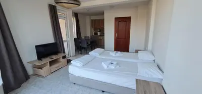 a bedroom with two beds and a flat screen tv at Къща за гости Беглик Таш 2 in Primorsko