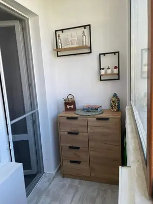 a wooden dresser in a room with a window at My Sweet Home in Burgas City