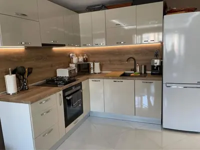 a kitchen with white cabinets and a white refrigerator at My Sweet Home in Burgas City