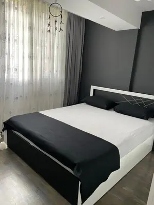 a bedroom with a black and white bed and a chandelier at My Sweet Home in Burgas City