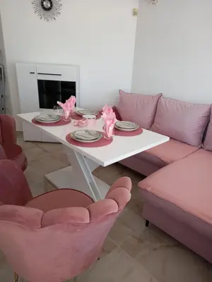 a living room with a white table and pink chairs at Perla 2 studio in Burgas City
