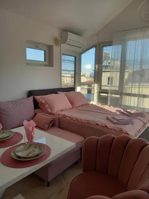 a bedroom with a large bed and a couch at Perla 2 studio in Burgas City