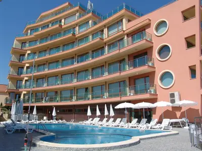 a hotel with a swimming pool in front of a building at Апартаменти СЪНИ БЕЙ in Sunny Beach