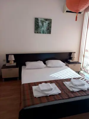 a bedroom with a bed with two towels on it at Апартаменти СЪНИ БЕЙ in Sunny Beach