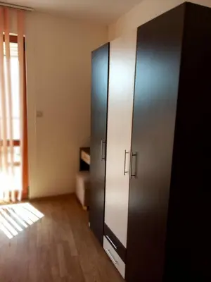 a black cabinet in a room with a wooden floor at Апартаменти СЪНИ БЕЙ in Sunny Beach