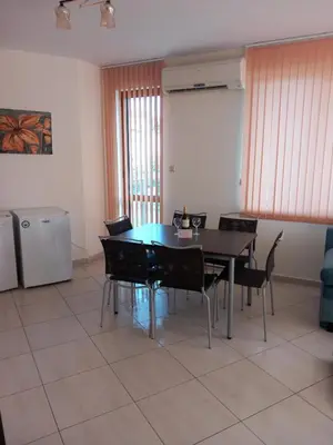 a dining room with a table and chairs at Апартаменти СЪНИ БЕЙ in Sunny Beach