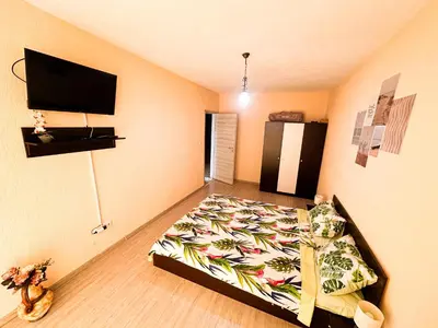 a bedroom with a bed and a flat screen tv at Blue Sky Apartments in Nesebar