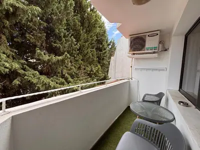 a balcony with two chairs and a window with a tree at Sozopol Romance Apartments in Sozopol
