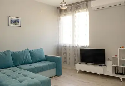 a living room with a blue couch and a television at ~ The Blue ~ 1BD Flat near Asparuhovo Sea Garden in Varna City