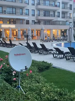 a satellite dish in front of a building with a pool at Studio in Sveti Vlas