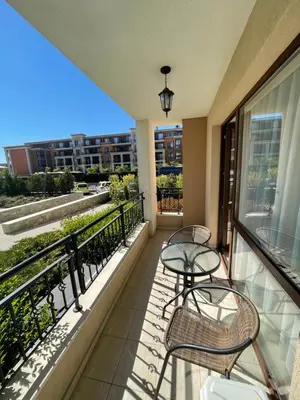a balcony with two tables and chairs on a building at Studio in Sveti Vlas
