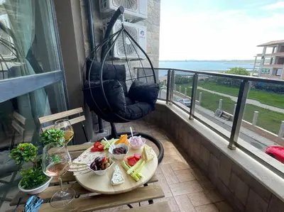 a table with food and wine on a balcony at Brand new first line Sea view 1 bedroom apartment in Burgas City