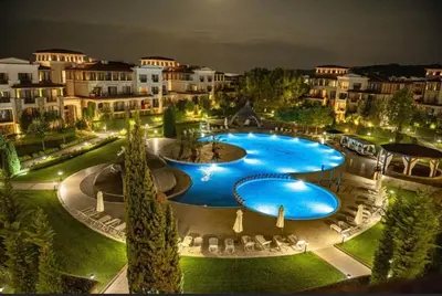 a large swimming pool in a resort at night at Green Life Private apartments in Sozopol
